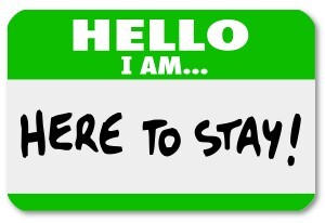 A namtag sticker with the words Hello I Am Here to Stay to symbo