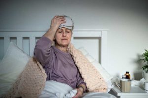 elderly woman in bed with headache